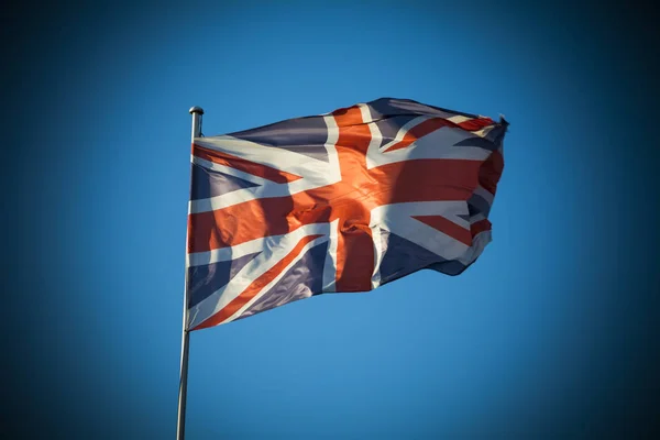 Union Jack en la luz del sol contra el cielo azul claro —  Fotos de Stock