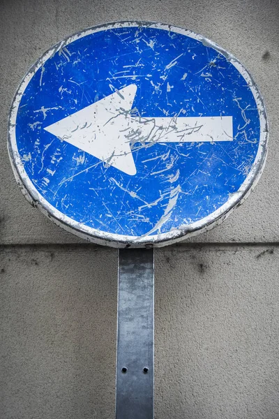 Sväng vänster väderbitna och repad riktning tecken — Stockfoto