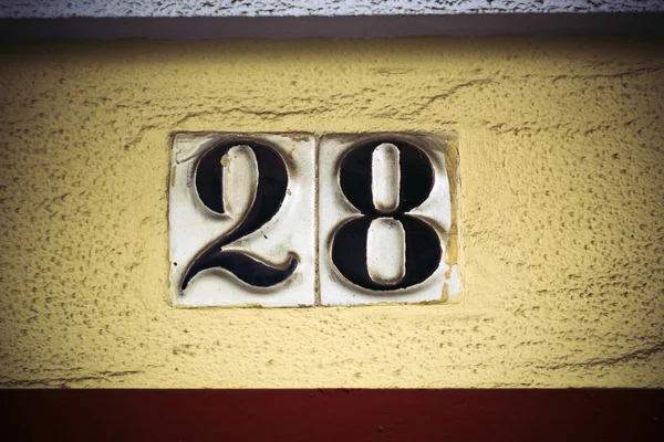 Número veintiocho en cifras elevadas en la pared de yeso — Foto de Stock