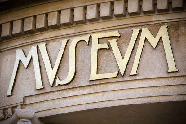 Golden museum sign at entrance to cultural centre — Stock Photo, Image