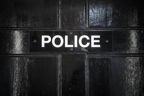 Police sign on black doorway at entrance to police station — Stock Photo, Image