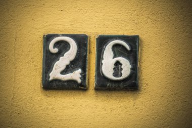 Alçı duvar üzerinde yükseltilmiş rakamlarla yirmi altı numara