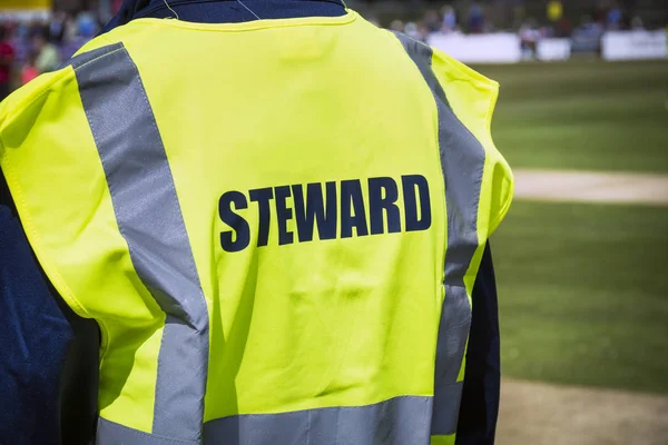 Sports steward by pitch in high viz jacket — Stock Photo, Image