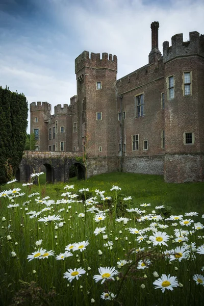 Schloss Herstmonceux auf seinem Gelände mit Gänseblümchen im Vordergrund — Stockfoto