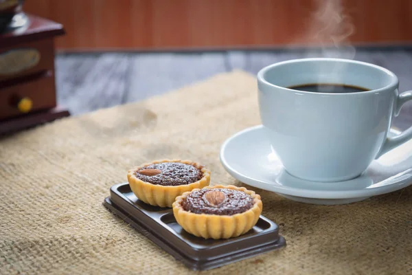 Кофейные чашки и кофейные зёрна с пирожными — стоковое фото