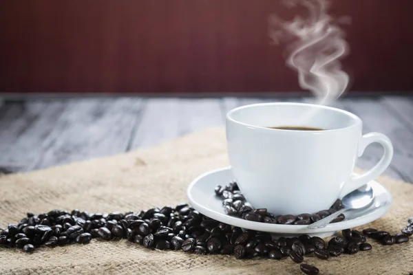 Xícara de café e grãos em um fundo rústico. Café Espresso e — Fotografia de Stock