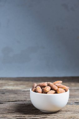 Beyaz kase içinde tuz kavrulmuş badem 