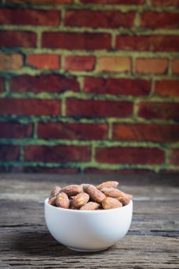 Beyaz kase içinde tuz kavrulmuş badem 