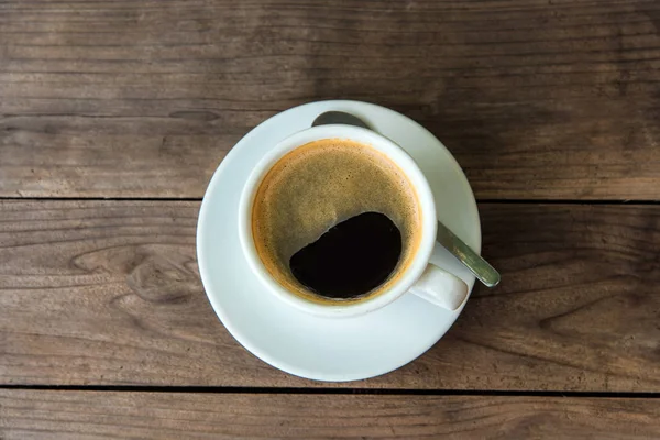 Taza de café fresco con granos de café en la mesa de madera —  Fotos de Stock