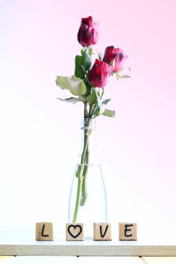  Kalp ve ahşap alfabe ile kırmızı gül