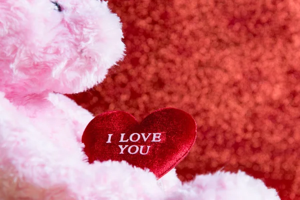 Ursinho de pelúcia com coração no fundo vermelho, conceito valentine — Fotografia de Stock