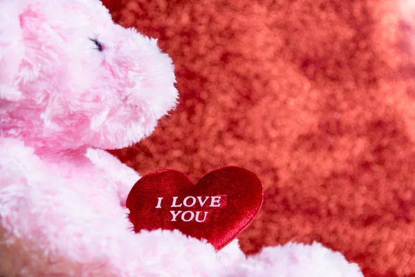 Osito de peluche con corazón sobre fondo rojo, concepto valentine — Foto de Stock