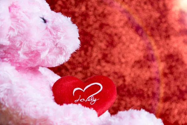 Плюшевый медведь с сердцем на красном фоне, концепция валентина — стоковое фото