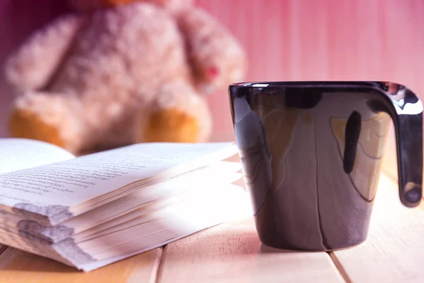 Kaffeetasse und Buch über Teddybär im unscharfen Hintergrund — Stockfoto