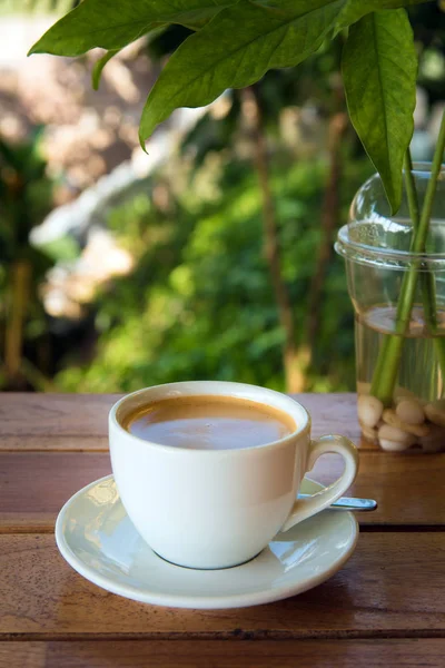 Tazza di caffè fresco con chicchi di caffè sul tavolo di legno — Foto Stock