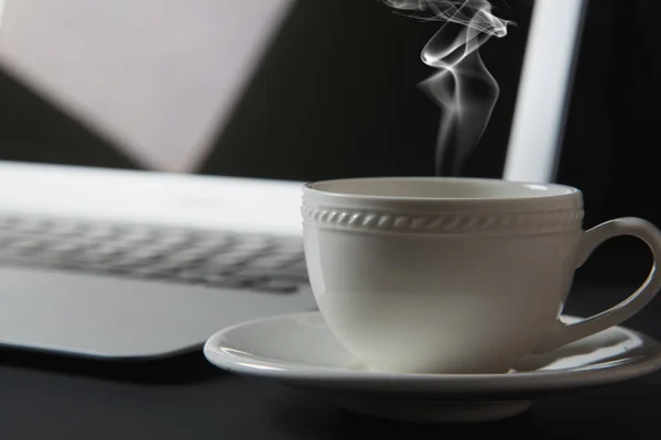 Filiżanka kawy i laptop na stole — Zdjęcie stockowe
