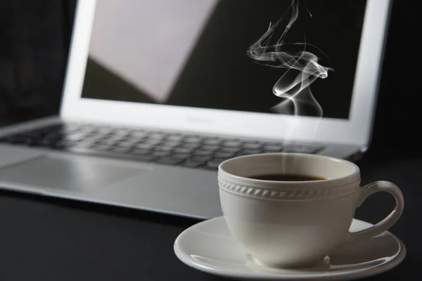 Taza de café y portátil en la mesa — Foto de Stock