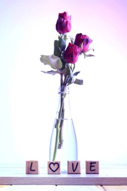  Kalp ve ahşap alfabe ile kırmızı gül