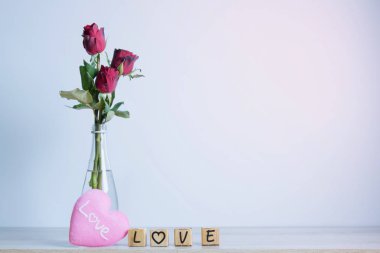  Kalp ve ahşap alfabe ile kırmızı gül