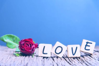  Kalp ve ahşap alfabe ile kırmızı gül