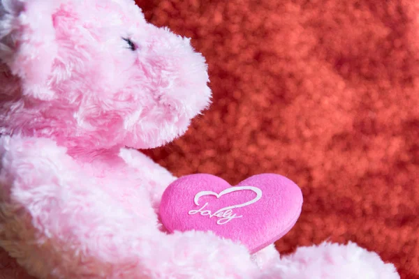 Ursinho de pelúcia com coração no fundo vermelho, conceito valentine — Fotografia de Stock