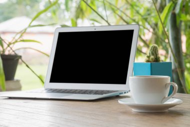 Açık havada ahşap bir masa üstünde laptop