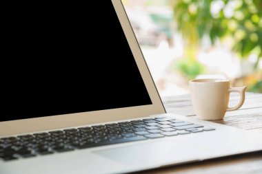 Açık havada ahşap bir masa üstünde laptop