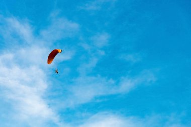 Paramotor 'a binen adam gökyüzünde uçuyor.