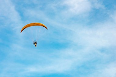 Paramotor 'a binen adam gökyüzünde uçuyor.
