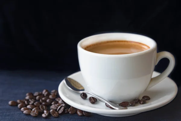 Tazza di caffè e fagioli su sfondo scuro — Foto Stock