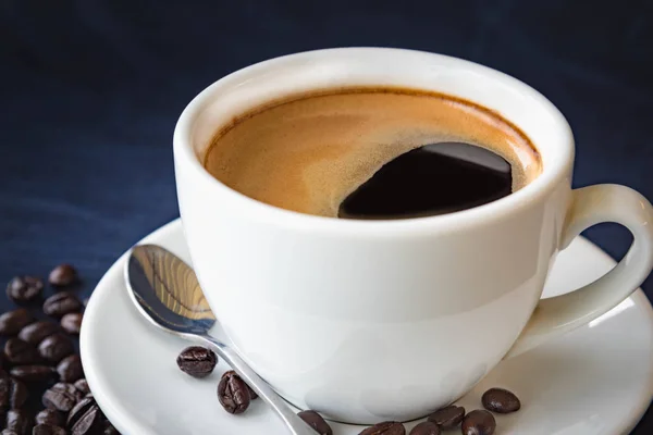 Tazza di caffè e fagioli su sfondo scuro — Foto Stock