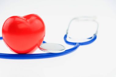 Beyaz zemin üzerine kırmızı kalp ile mavi stetoskop ve loptop bilgisayar.