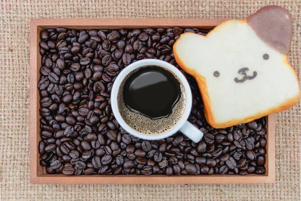 Xícara de café e grãos de café na caixa — Fotografia de Stock