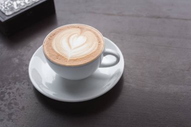 Kahve fincanı ahşap masada.