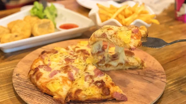 Pizza auf Holzteller gelegt — Stockfoto
