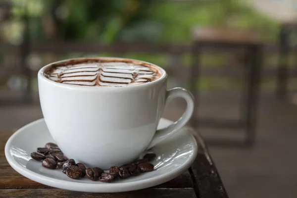 White coffee mug on patterned old wooden floor.