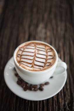 Desenli eski ahşap zemin üzerinde beyaz kahve kupa.