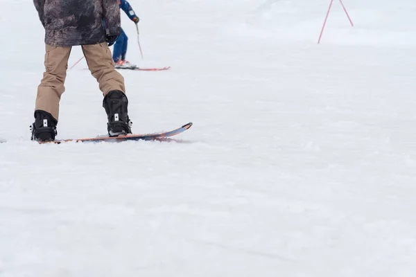 Esquiadores e snowboarders andando em uma pista de esqui — Fotografia de Stock