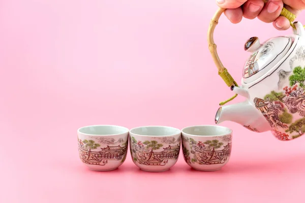 Tetera con tazas sobre fondo rosa . — Foto de Stock