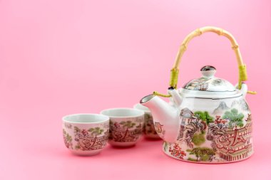 Çaydanlık bardak pembe bir arka plan üzerinde.