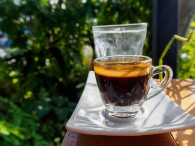 Masada bir fincan espresso. Kokteyl ya da kahve için cam deney şişesi. Bir bardak espresso iç. Beyaz arka planda çift duvarlı sıcak kahve..