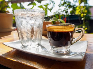 Masada bir fincan espresso. Kokteyl ya da kahve için cam deney şişesi. Bir bardak espresso iç. Beyaz arka planda çift duvarlı sıcak kahve..