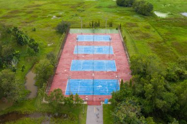 Kırsal alanda tenis kortunun havadan görünüşü, tel örgünün arkasındaki tenis kortu, kimsenin oynamadığı bir ağ., 