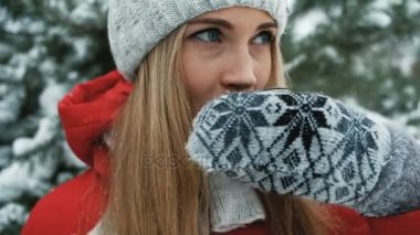 Sevimli sarışın sıcak çay çerçevede kış manzarası vardır