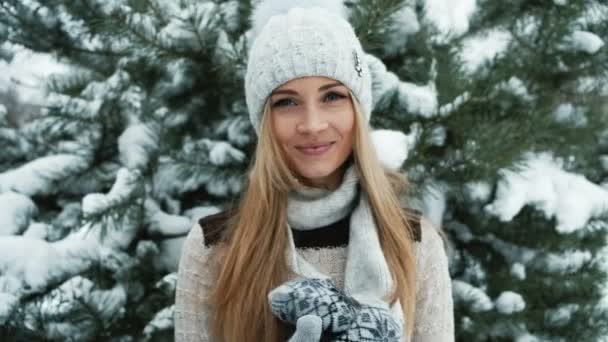 Entzückendes blondes Lächeln vor dem Hintergrund der schneebedeckten Landschaft. — Stockvideo