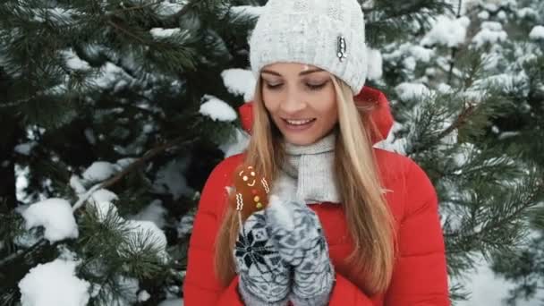 Närbild blond kvinna promenader, äta pepparkakor i vinterlandskap — Stockvideo