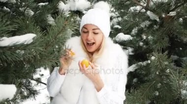 Güzel sarışın çerçevede kış peyzaj mandalina yiyor