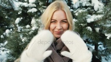 Ormandaki o elleri mittens içinde dalgalar ve öpücük gönderir.