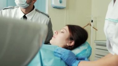 Doktor ve Yardımcısı şezlong içinde diş hekimliği hasta yatan yakınındaki