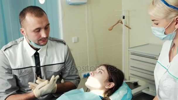 Tandläkare och assistent tala med klienten innan de behandlar. — Stockvideo